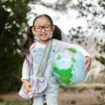 smiling girl holding an inflatable globe