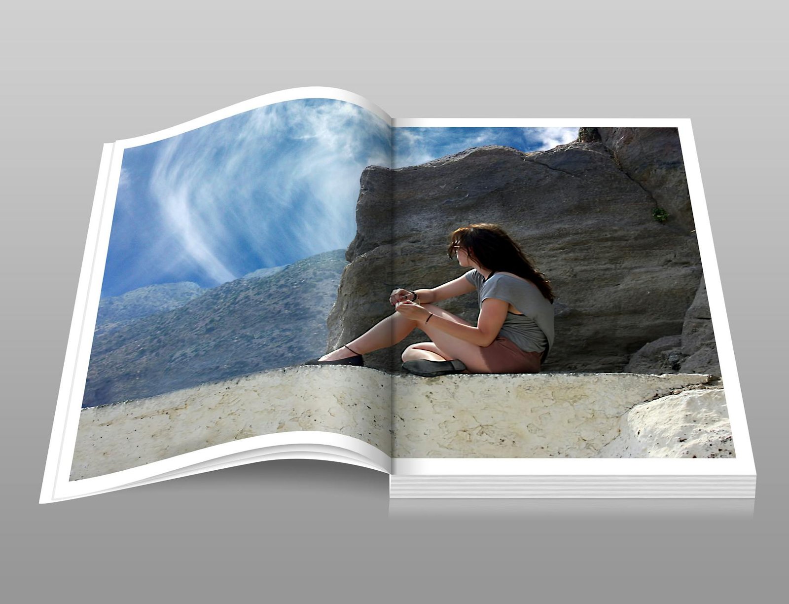 woman in gray shirt sitting over brown formation of rock during daytime book