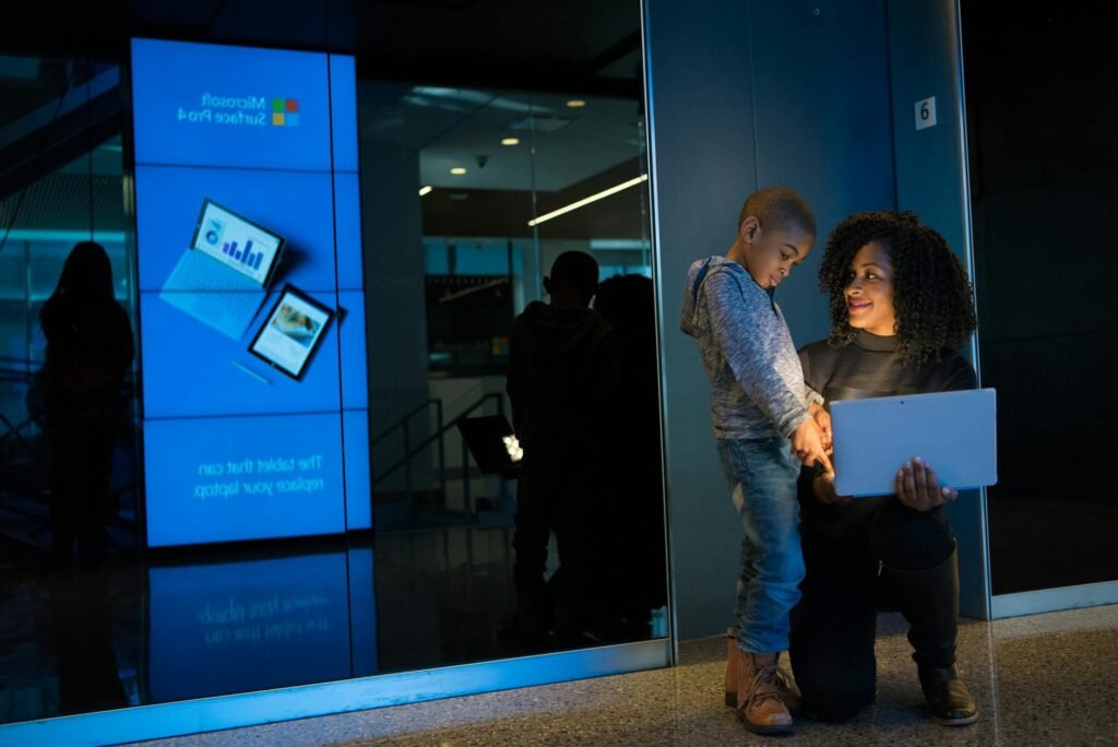 woman together with children holding laptop computer
