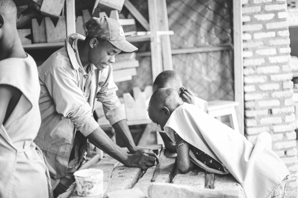 carpenter teaching two young boys in the workshop