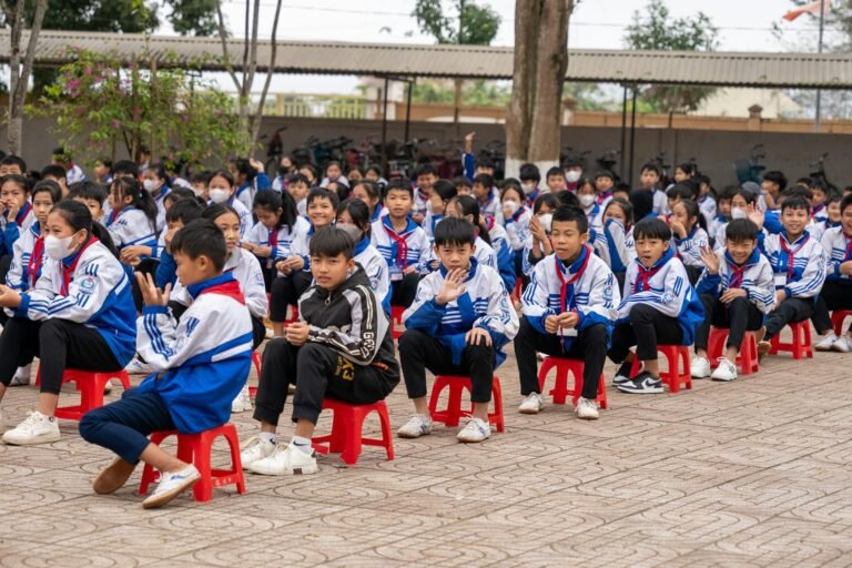 schoolkids sitting on the chairs outside