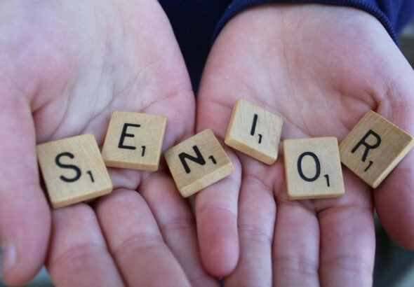 senior scrabble tiles held in hands