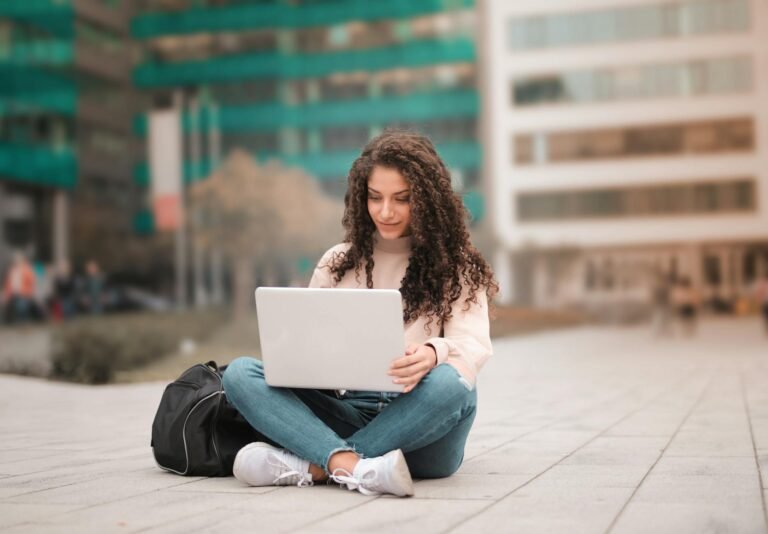 woman in pink sweater using laptop