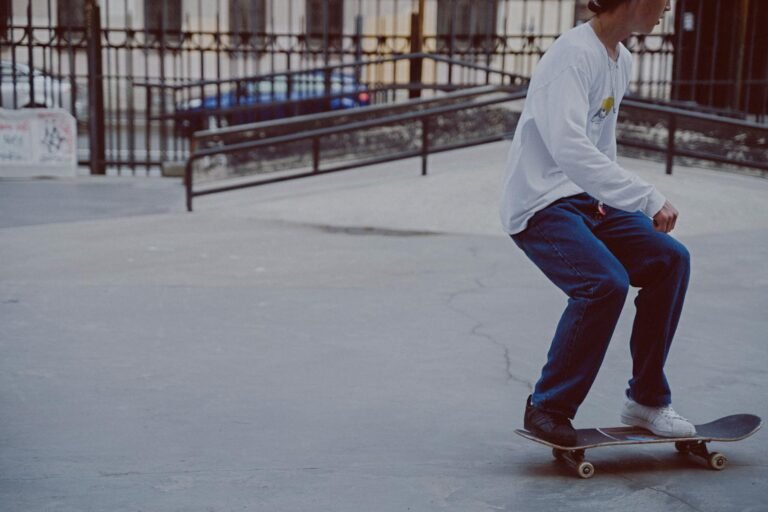 young man in white long sleeve shirt and blue denim jeans riding on skateboard