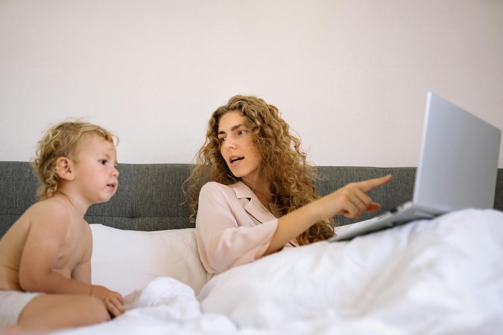 a mother pointing at the screen of a laptop