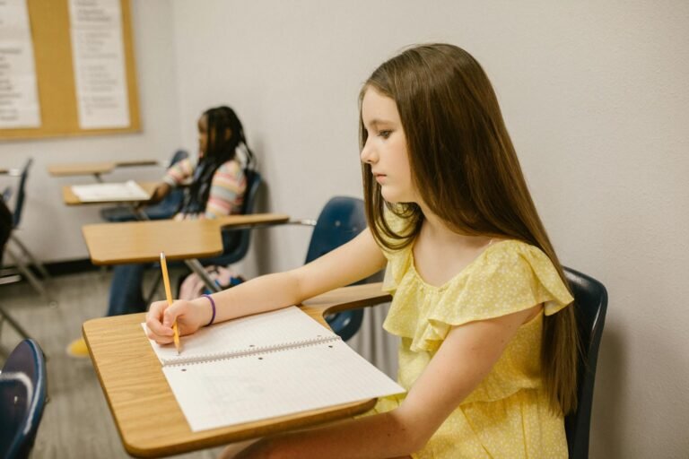 girl sitting on her desk looking lonely while writing notes on her notebook