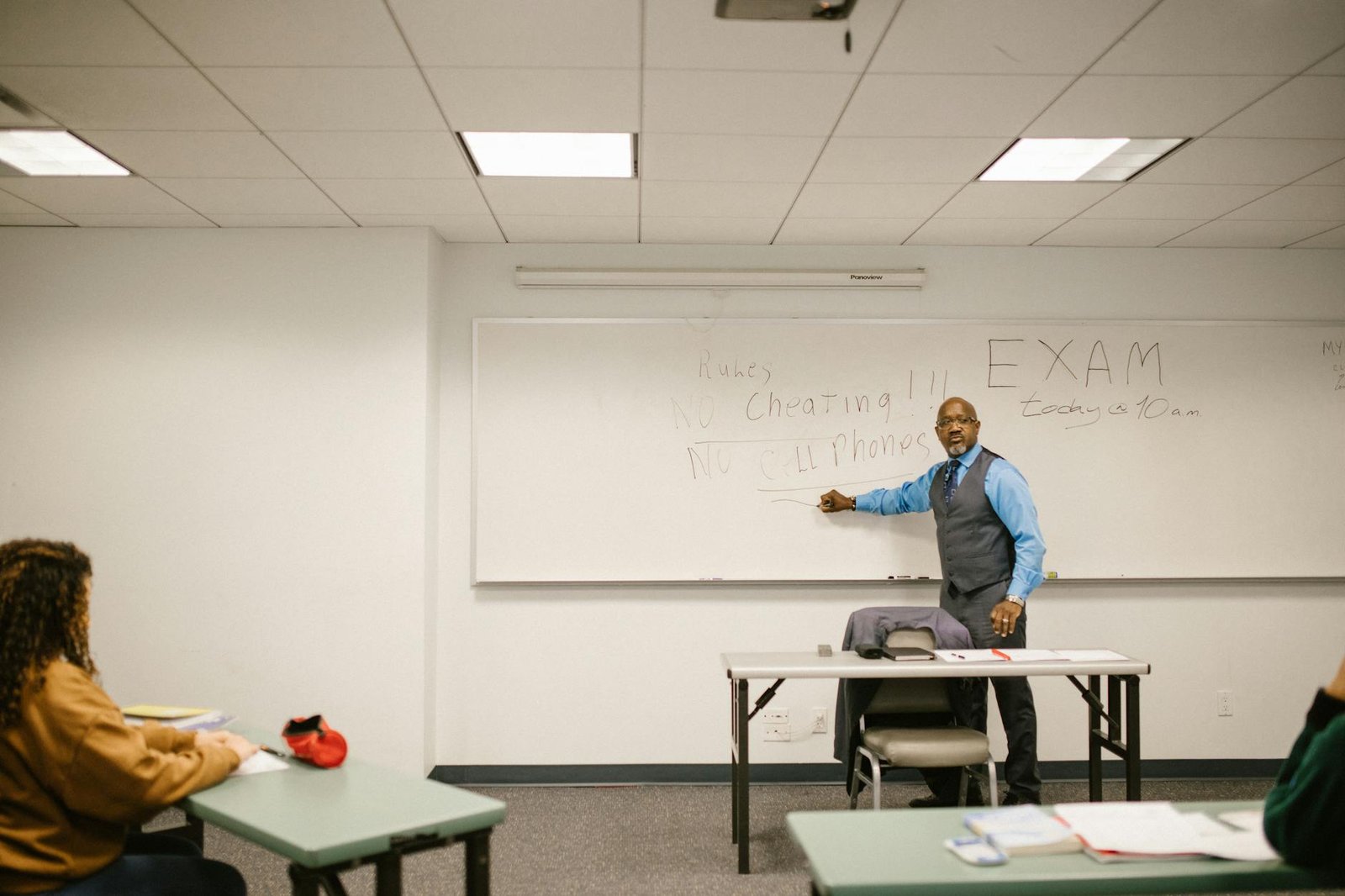 teacher giving instructions to his students not to cheat