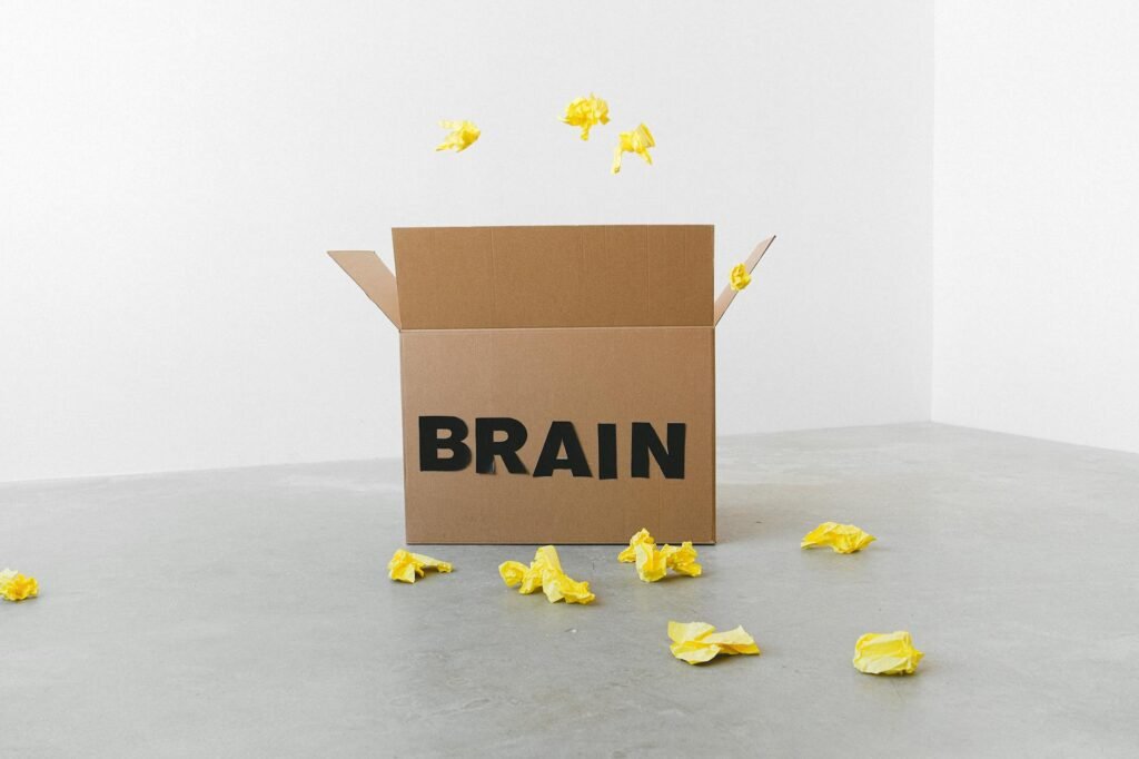 brain inscription on cardboard box under flying paper pieces