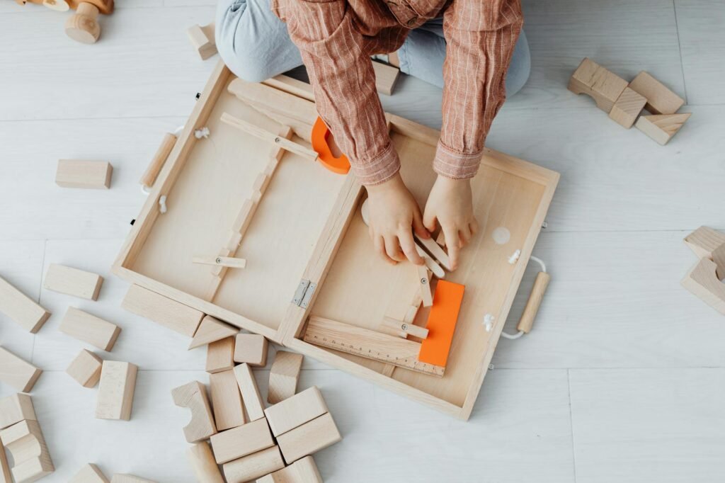 overhead shot of a kid s arms near wooden blocks
