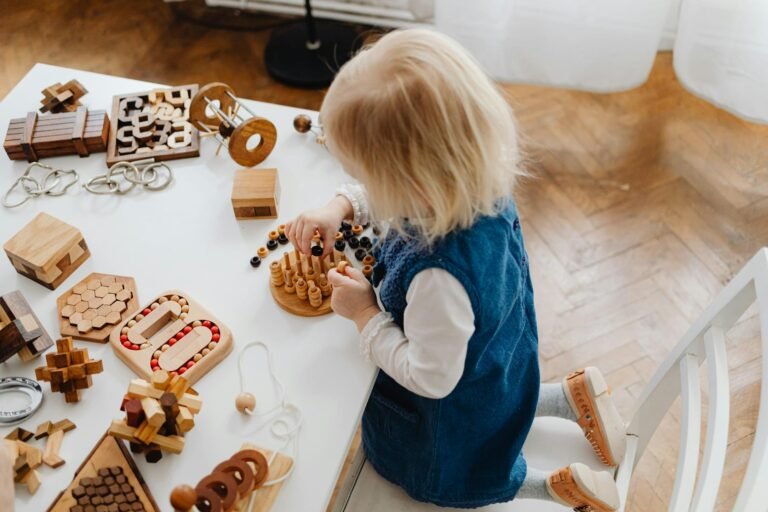 child kneeling at a table playing wit toys