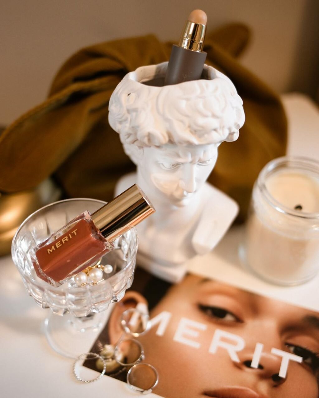 makeup products on a clear glass and a figurine