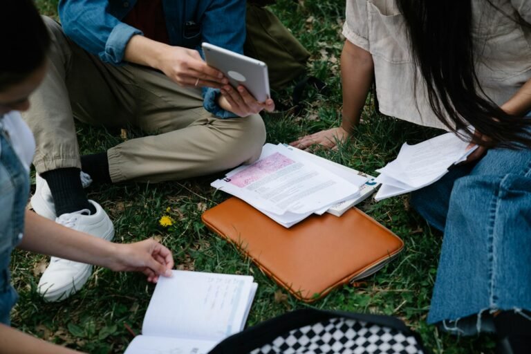 people sitting on grass studying