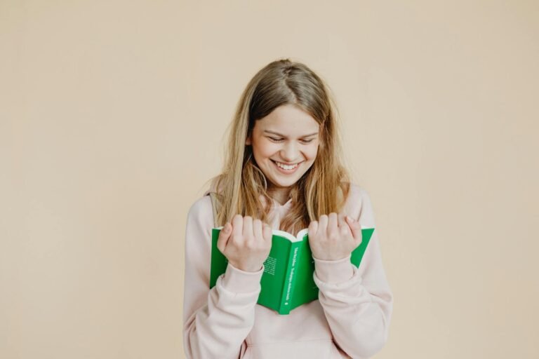 a happy woman in beige long sleeves reading a book
