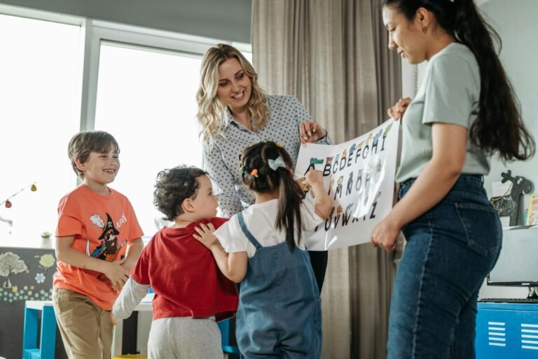 teachers holding a poster of the alphabets