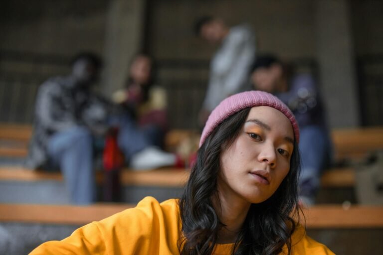 woman in yellow shirt wearing pink knit hat hanging out with friends