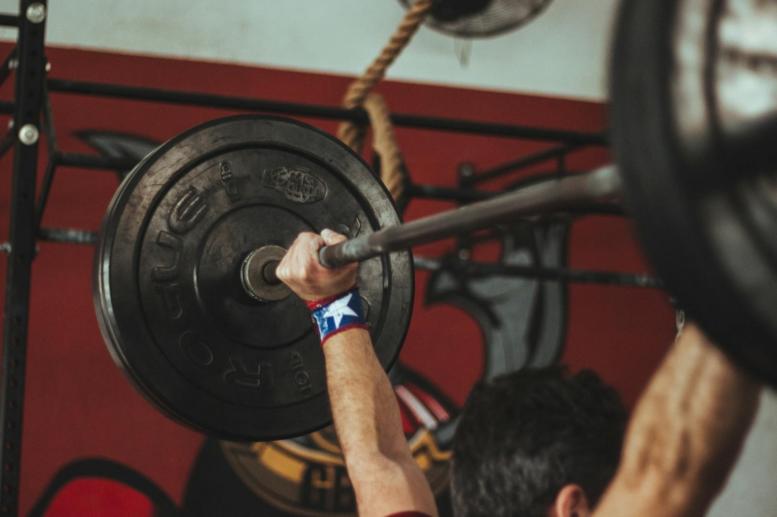 person carrying black barbell